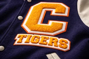 Chenille embroidery on varsity jacket showing raised fuzzy letter patch commonly used for varsity apparel and sports team branding.