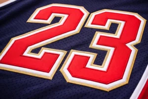 Tackle twill embroidery on sports jersey showing layered fabric numbers stitched with zigzag embroidery for durable athletic apparel branding.